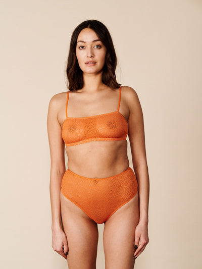 Kvindelig model iført vores Tora High String Orange. Set forfra.